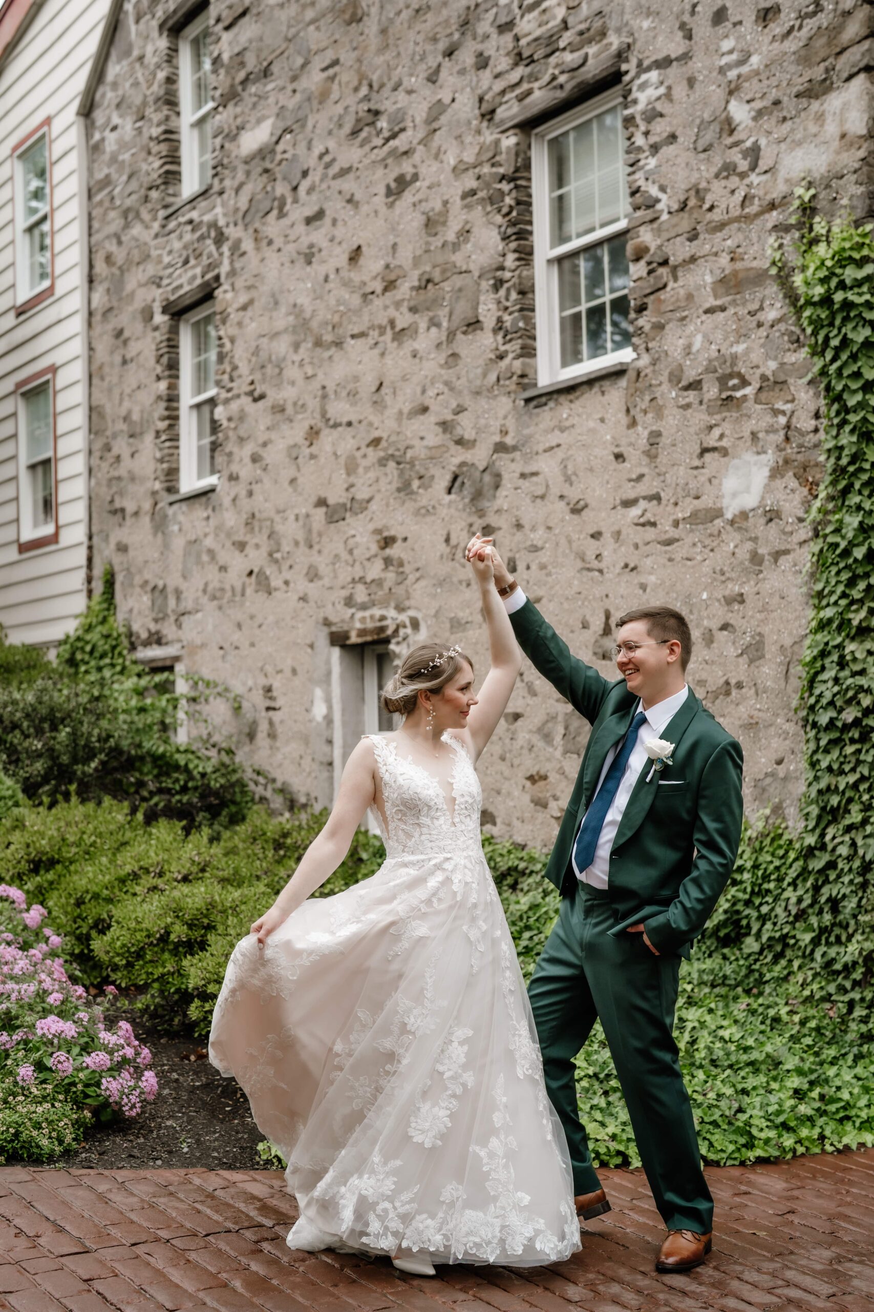 Groom twirls bride during portraits outside the Joseph Ambler Inn on their wedding day