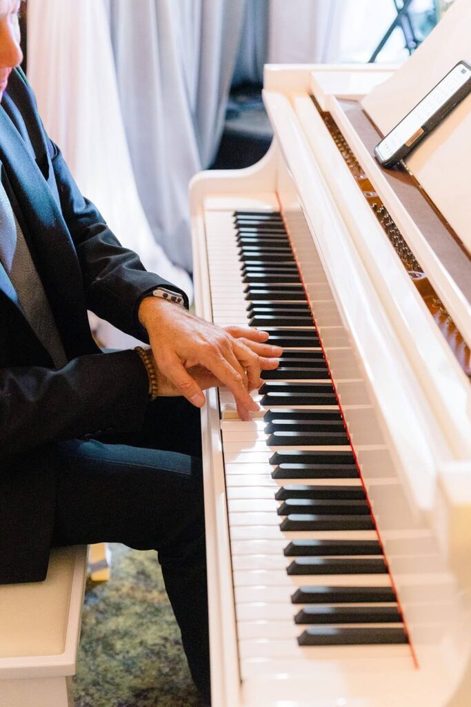 Pianist playing an elegant white piano during a winter gala