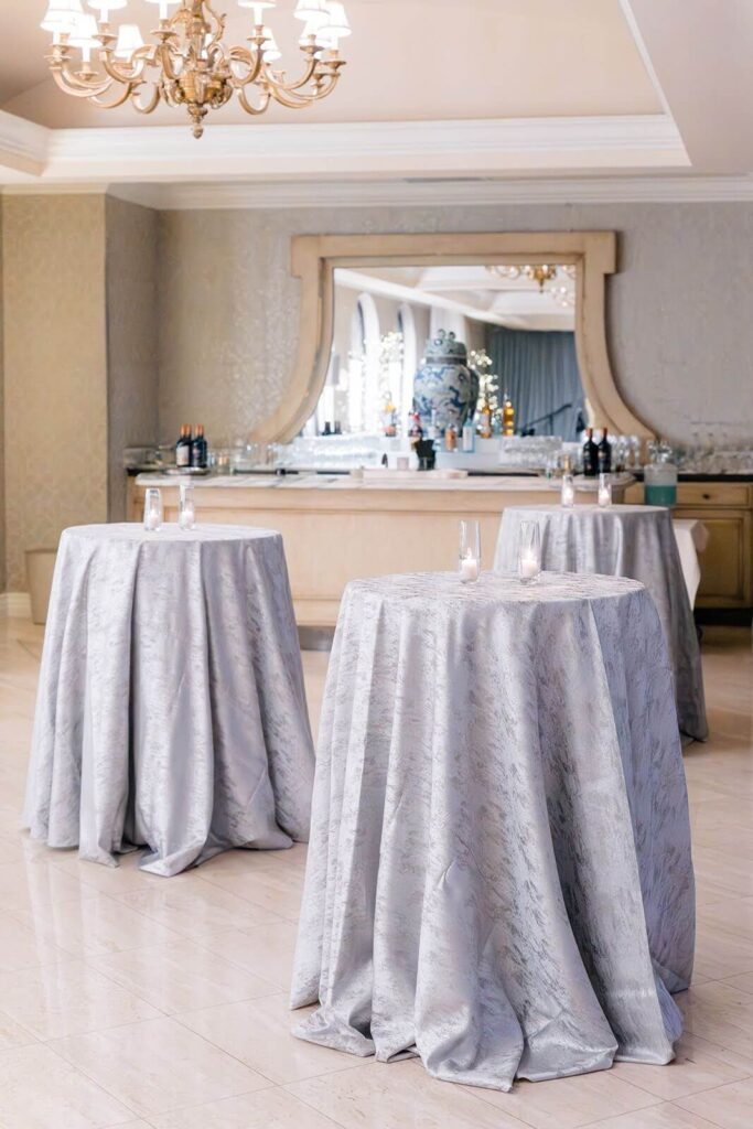 Cocktail tables styled for cocktail hour in icy blue tablecloths