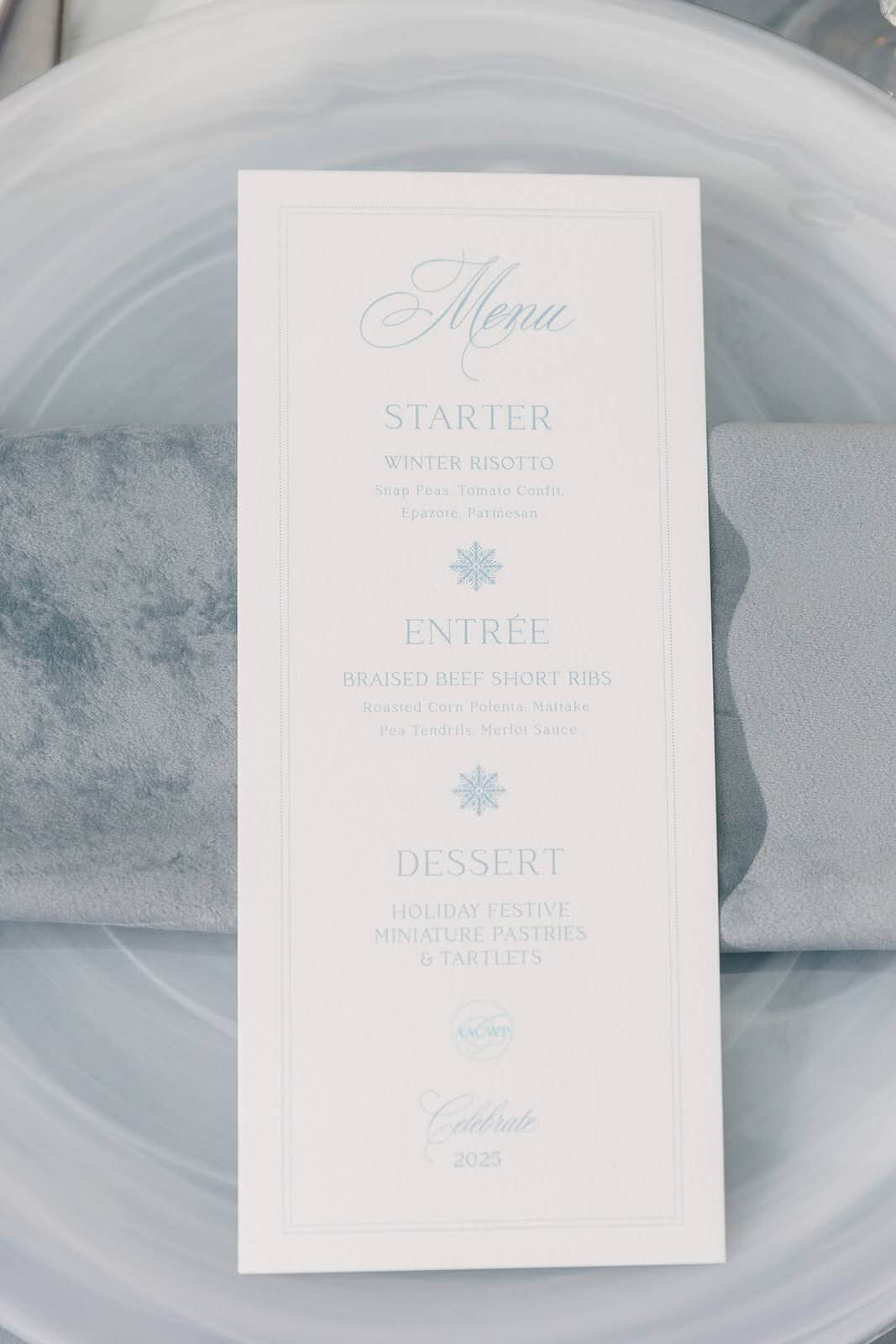 Elegant winter themed menu with snowflake icons on a place setting in icy blues