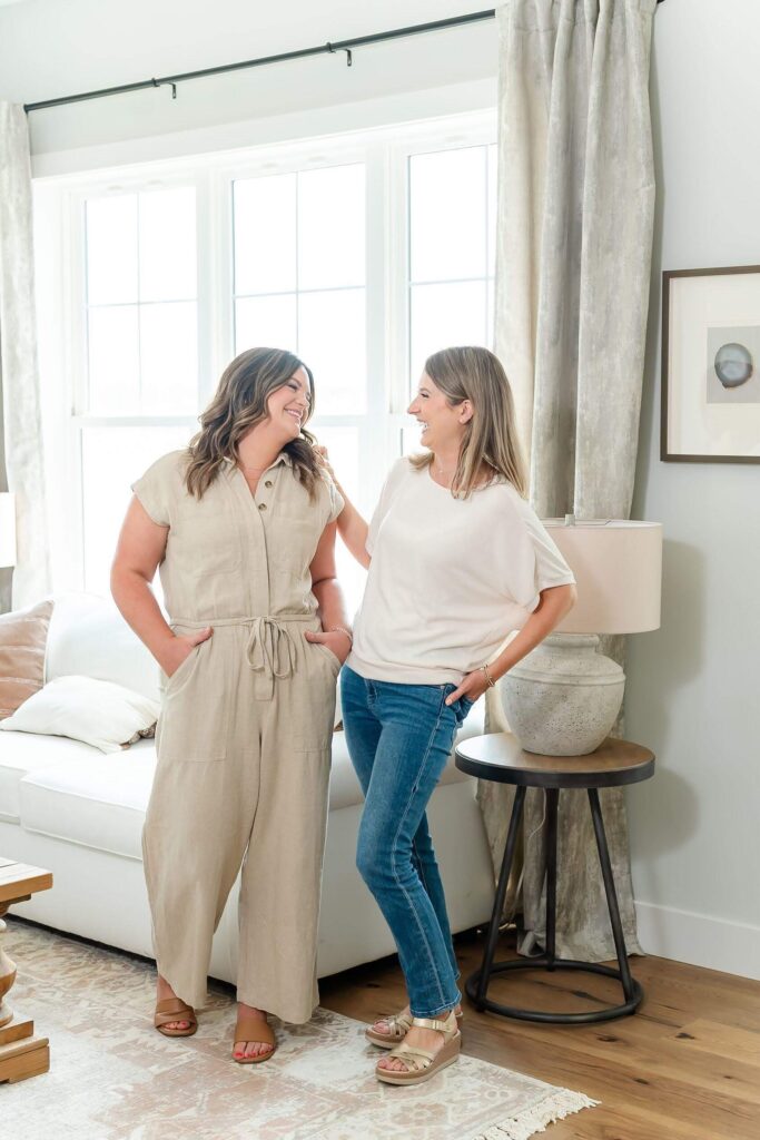 Wedding stationers Heather and Emily laughing while looking at each other during their branding photos in 2025