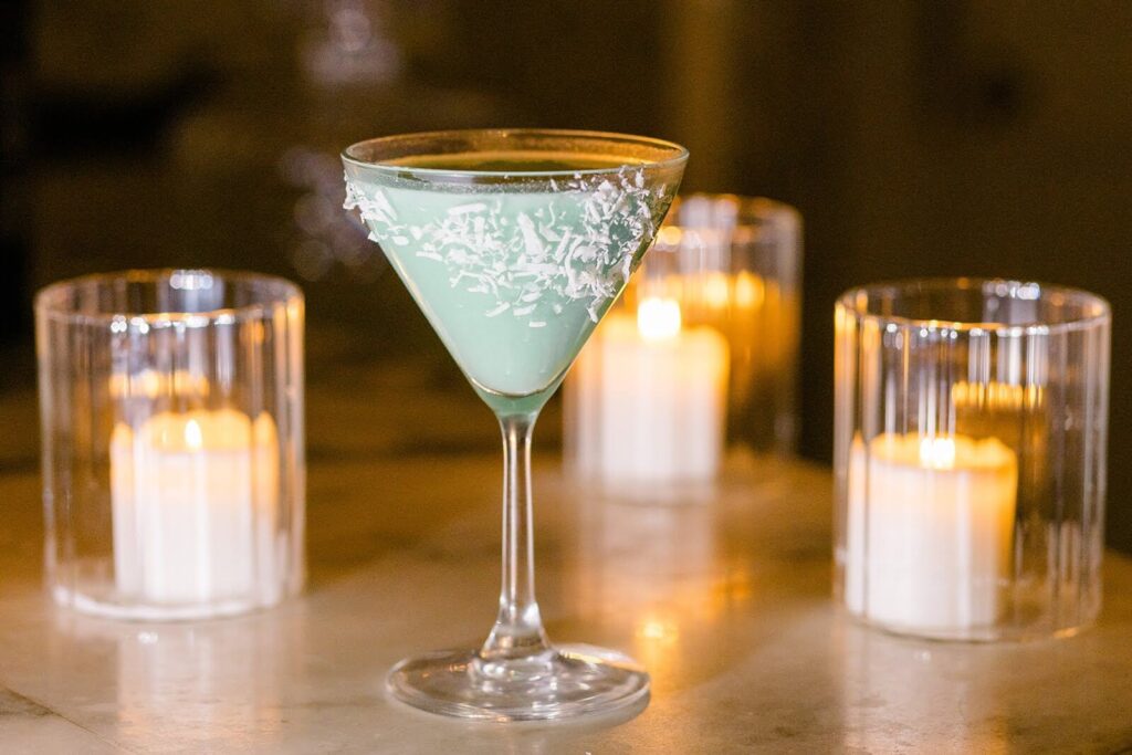 Winter themed cocktail surrounded by warm, romantic candles