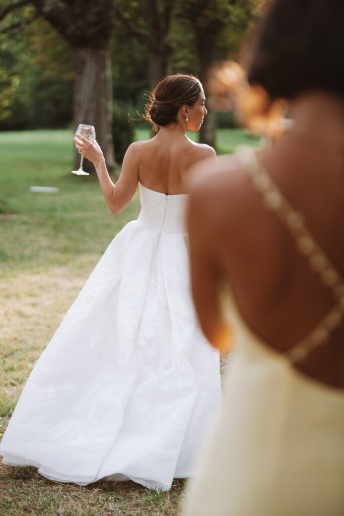 Bride walking with drink during cocktail hour
