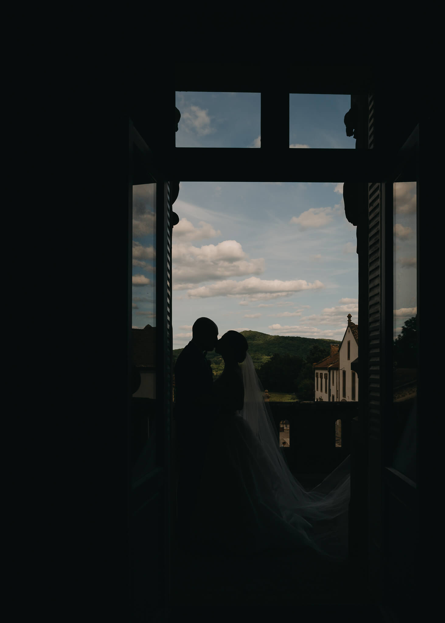 Bride and groom silhouette kissing with images from the French countryside in the background