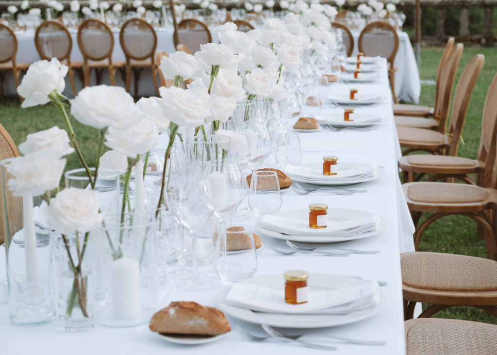 Sophisticated al fresco wedding reception table with honey jar guest favors