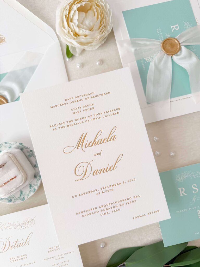 Formal white and gold letterpress wedding invitation with silk ribbon and gold wax seal