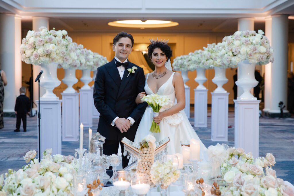 Bride and groom surrounded by elegant florals on their wedding day at the Palace Hotel