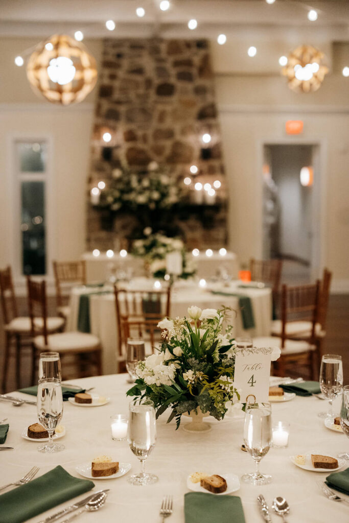 Elegant wedding table number card with gold stand in a candlelit ballroom