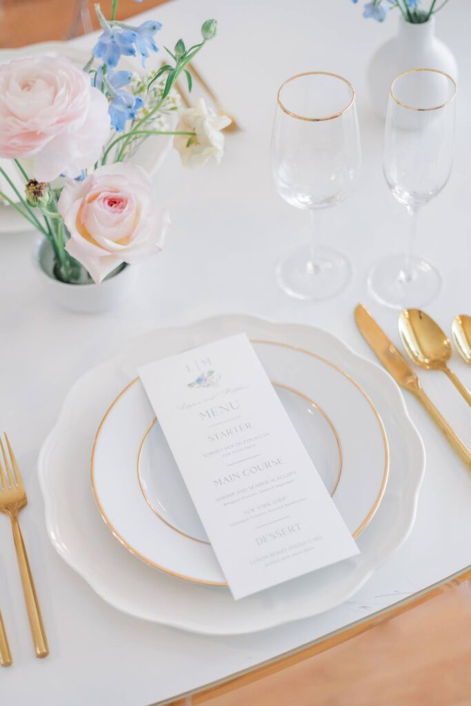 Elegant white and gold tablescape with a menu card