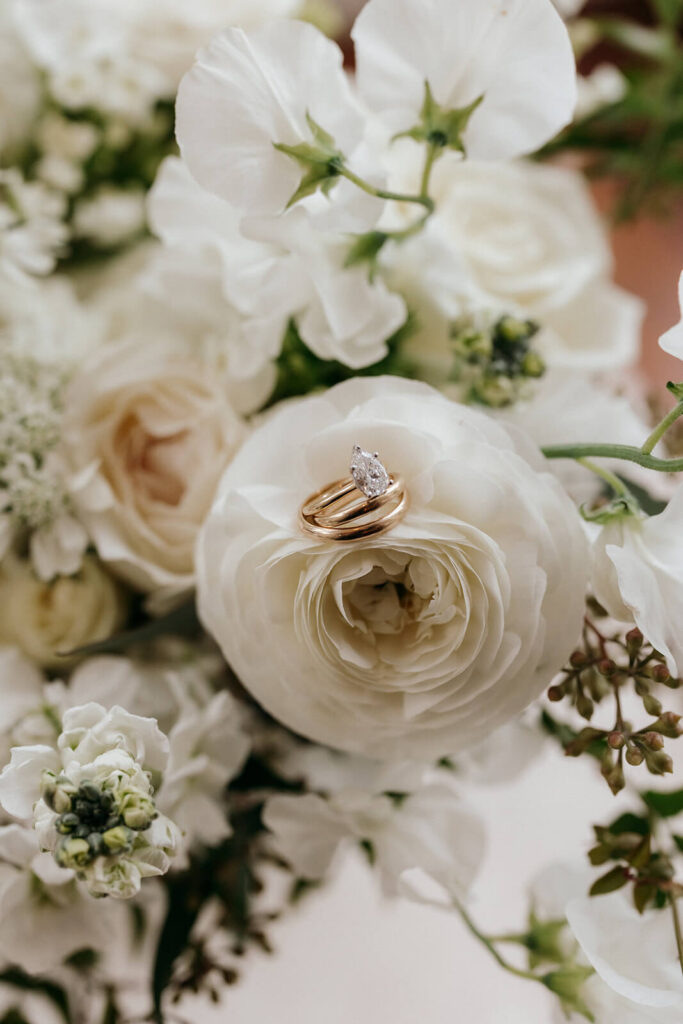 Wedding rings sitting on a bridal bouquet