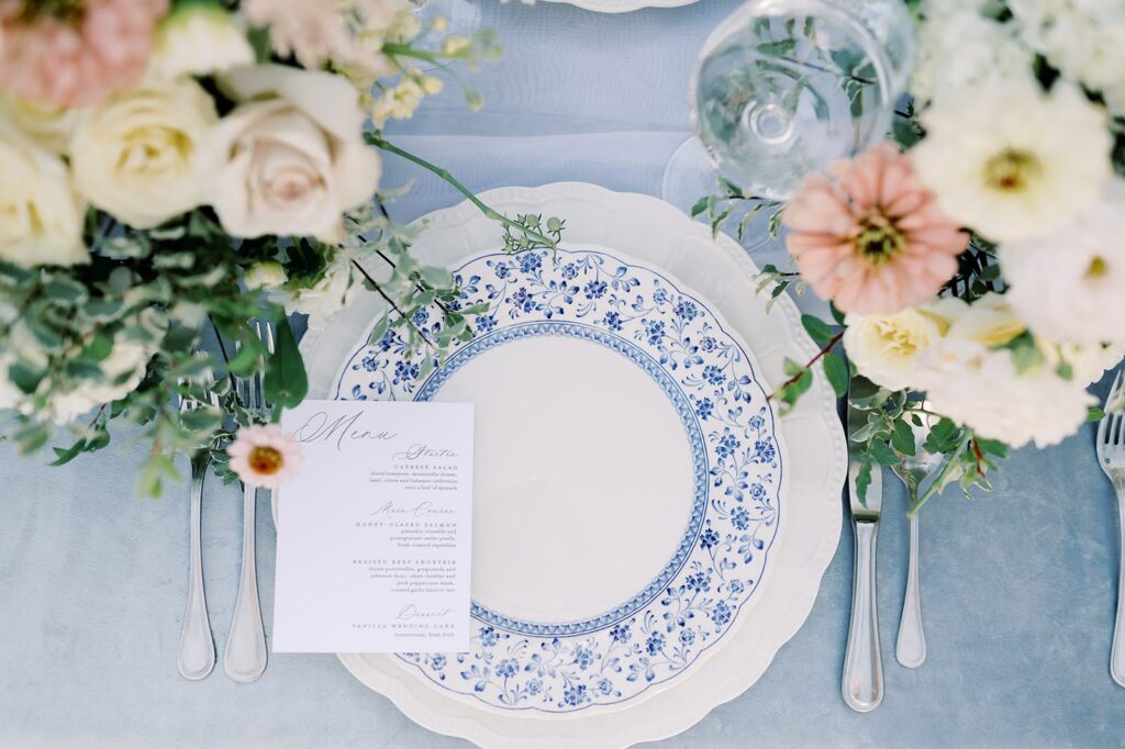Romantic tablescape with blue linens and a wedding menu card