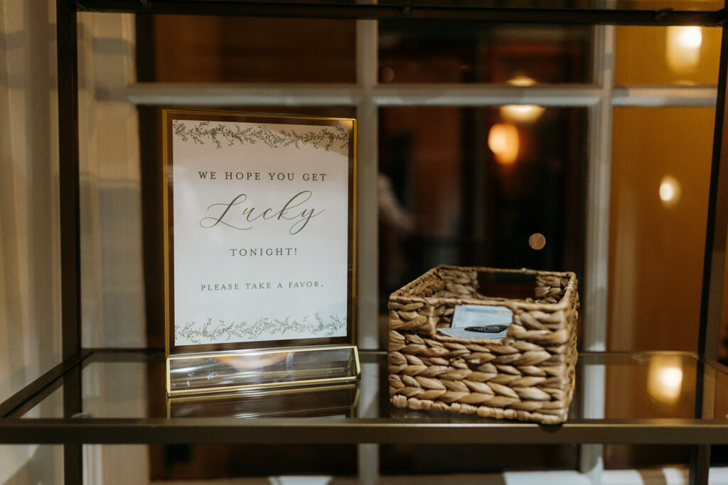 Elegant wedding favors sign displayed beside a basket of favors