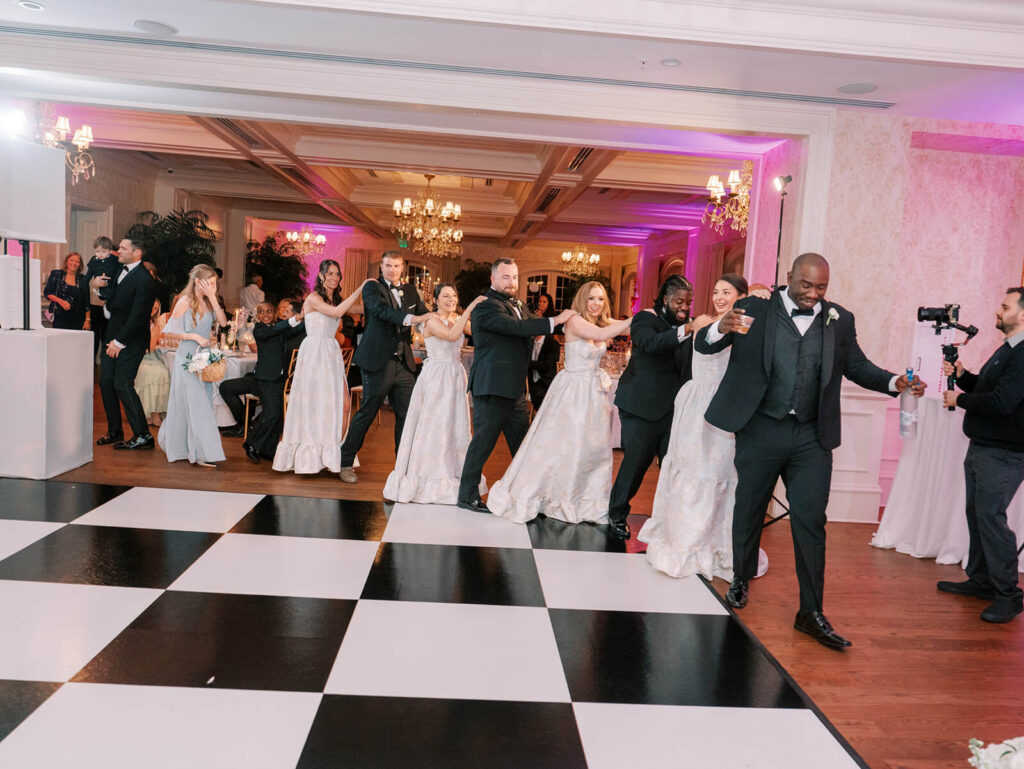 Wedding guests dance in a conga line
