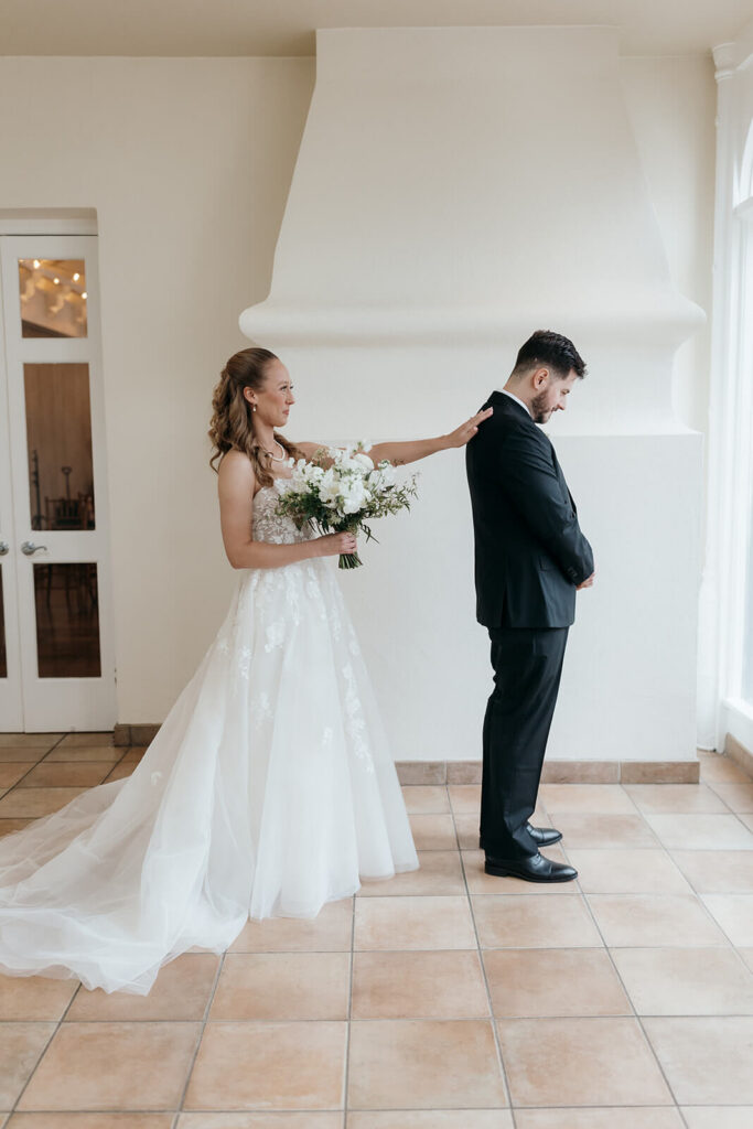 Bride taps groom's shoulder to turn for first look