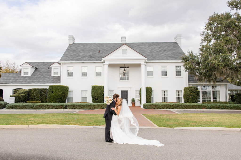 Bride and groom kiss outside Adams Estate wedding venue in Lake Alfred, Florida