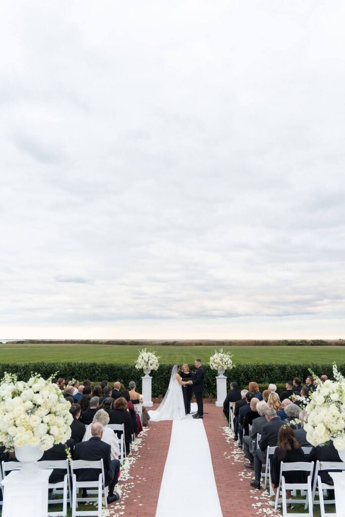 Bride and groom during their wedding ceremony overlooking the great lawn at Bourne Mansion