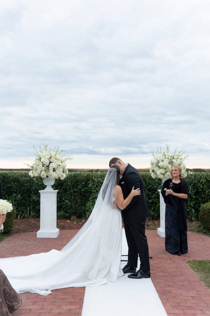 Bride and groom share their first kiss during their wedding ceremony at Bourne Mansion