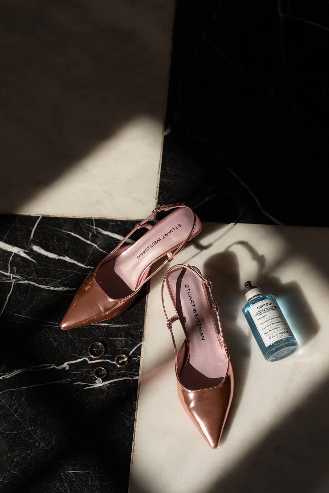 Flat lay of bridal details, including pink heels and perfume