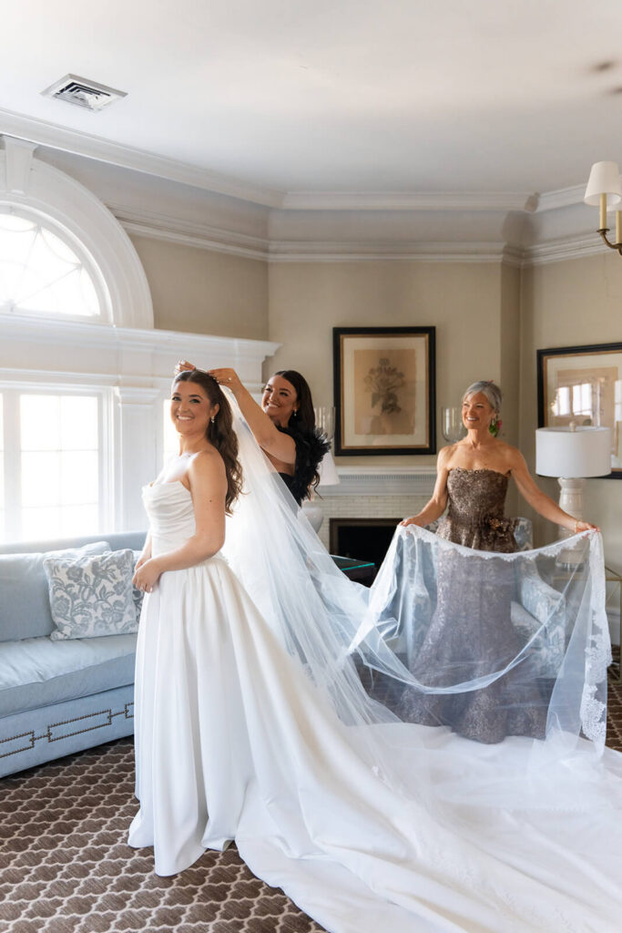 Bride's family members helping prepare her for her wedding day