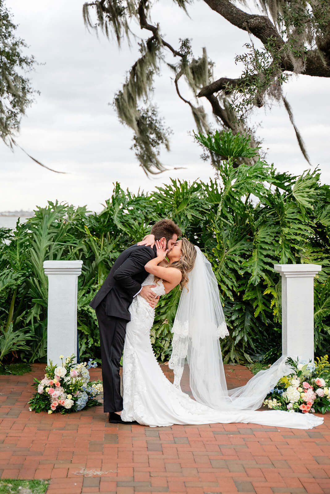 Bride and groom share their first kiss in the wedding garden at Adams Estate 