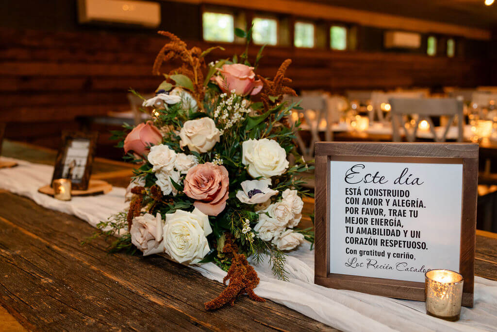Wedding reception welcome table with a Spanish sign greeting guests
