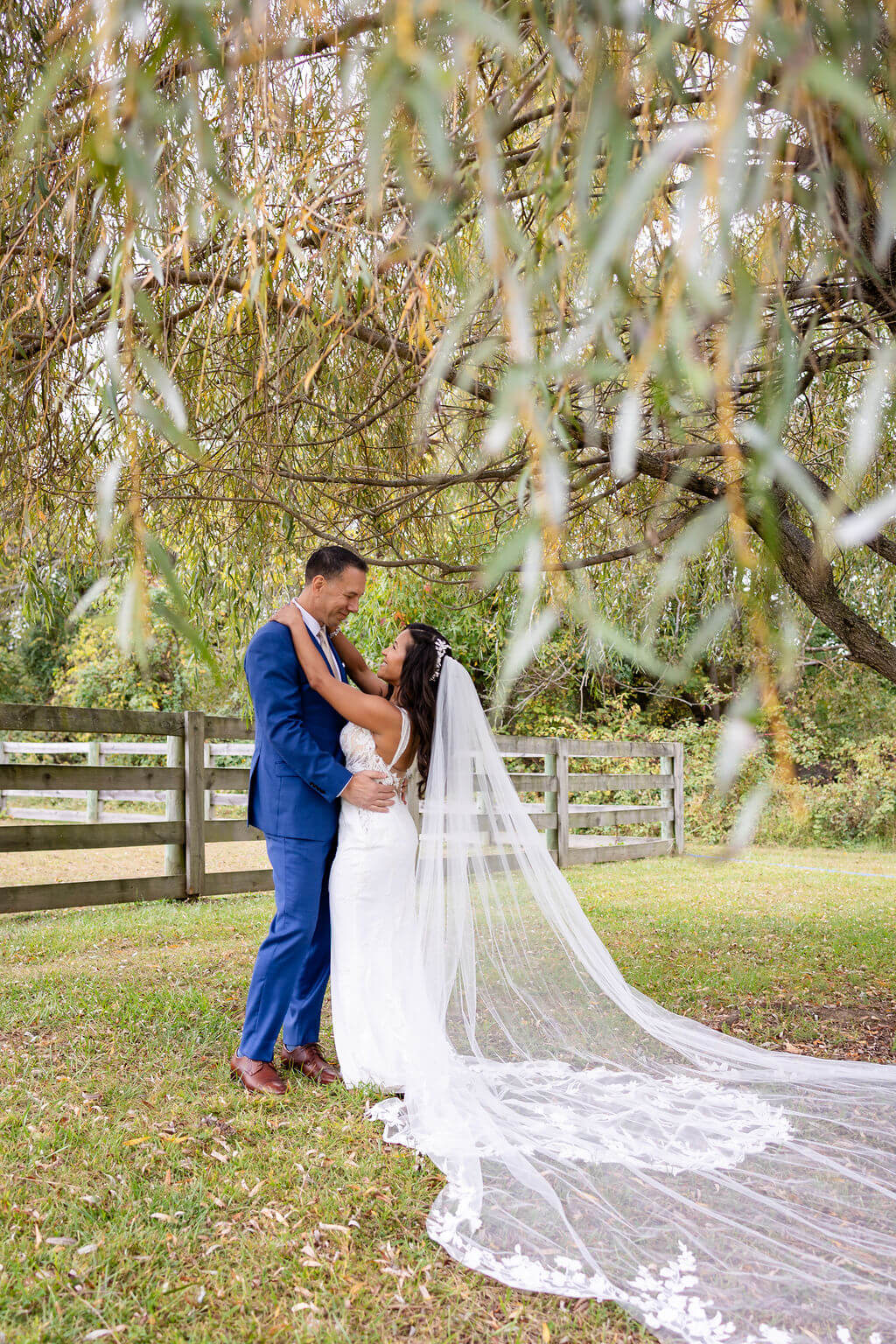 Bride and groom under a willow tree at their Cecil Creek Farm wedding
