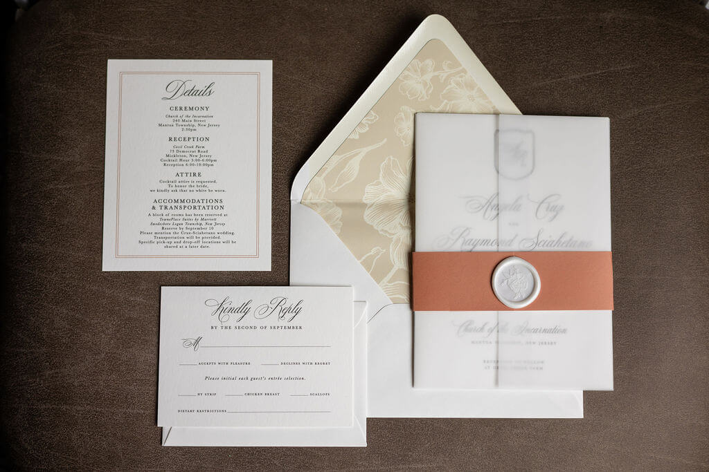 Elegant neutral wedding invitation suite with belly band, wax seal, and floral envelope liner