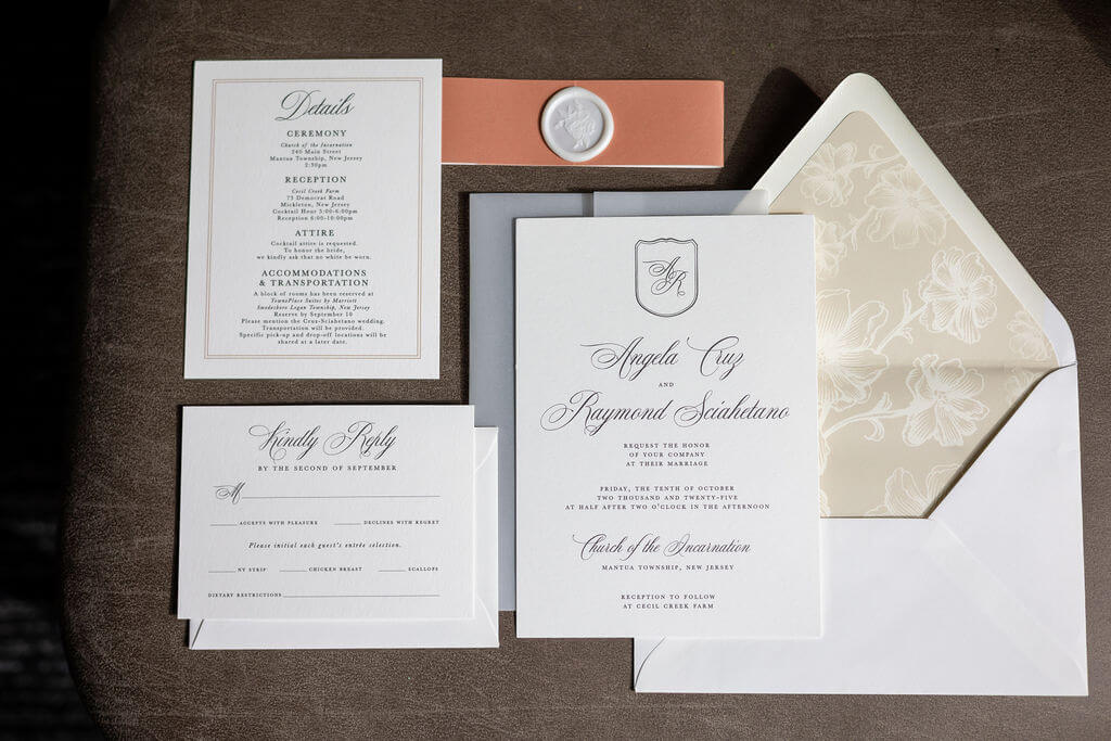 Elegant neutral wedding invitation suite with belly band, wax seal, and floral envelope liner