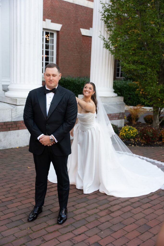 Bride tapping groom for first look