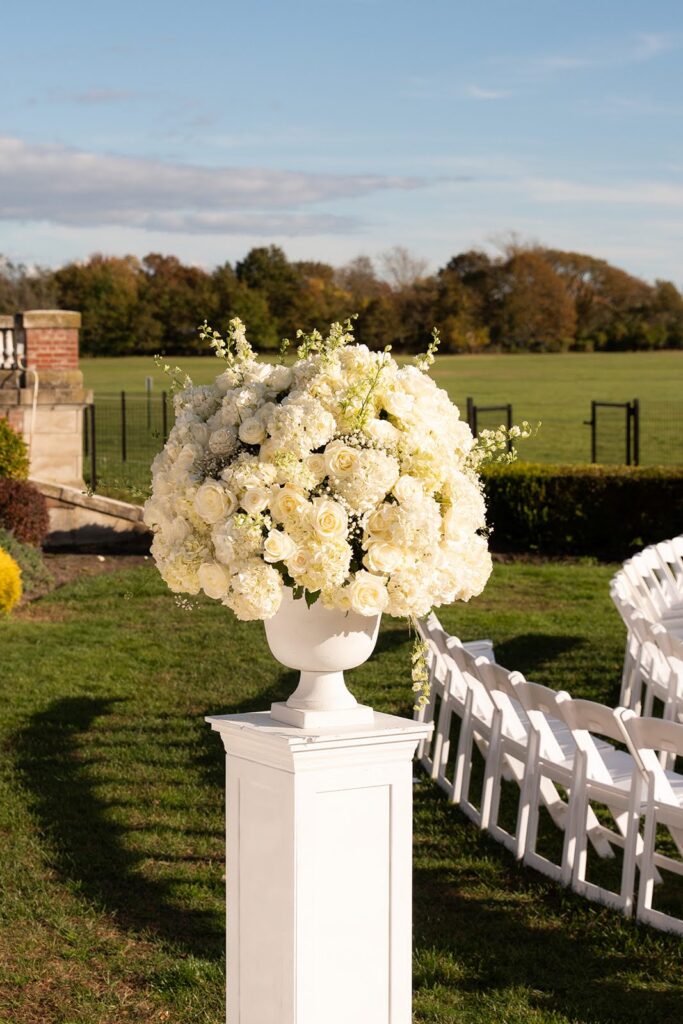 Formal white floral arrangement on a pedestal