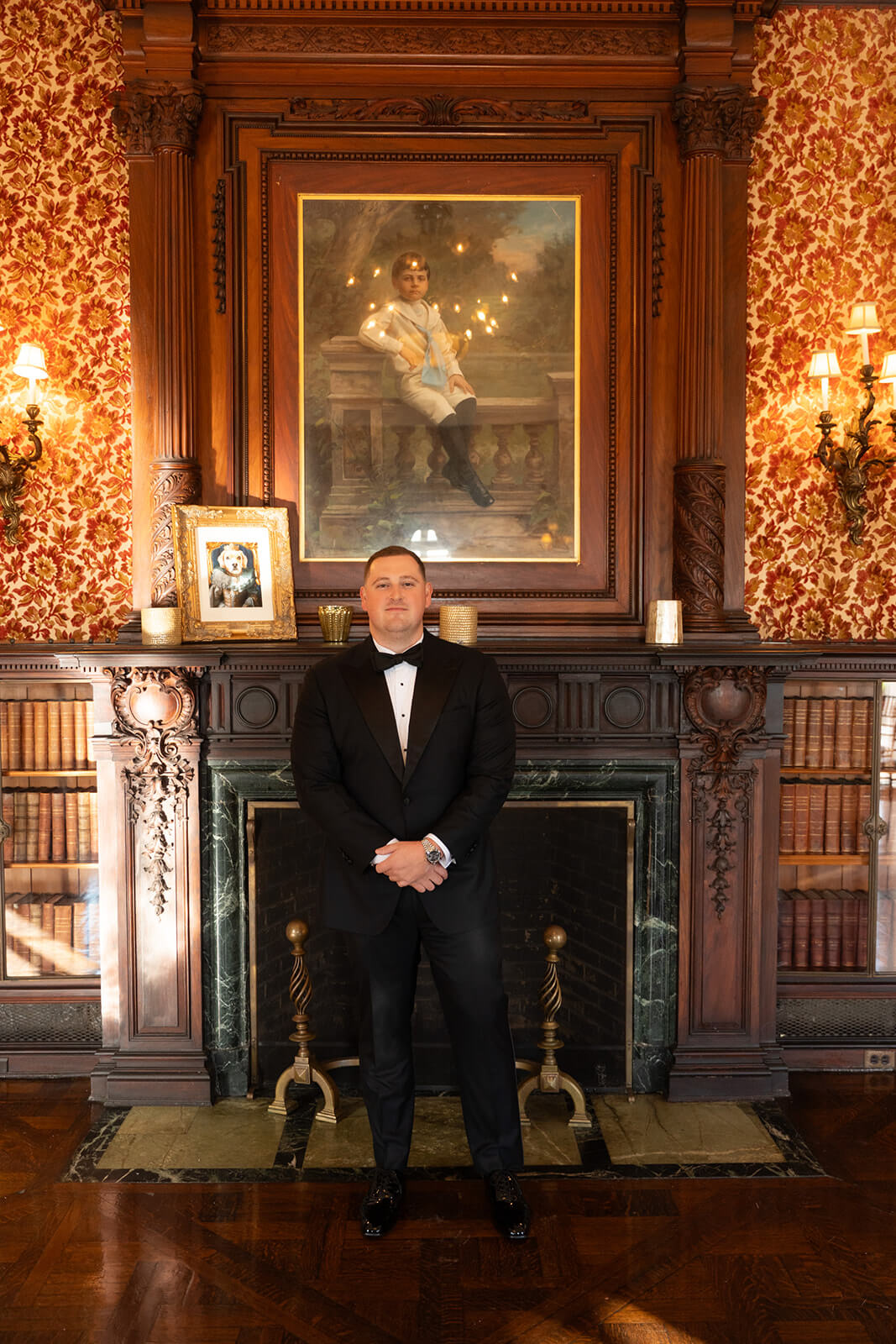 Portrait of the groom by a historic fireplace at Bourne Mansion