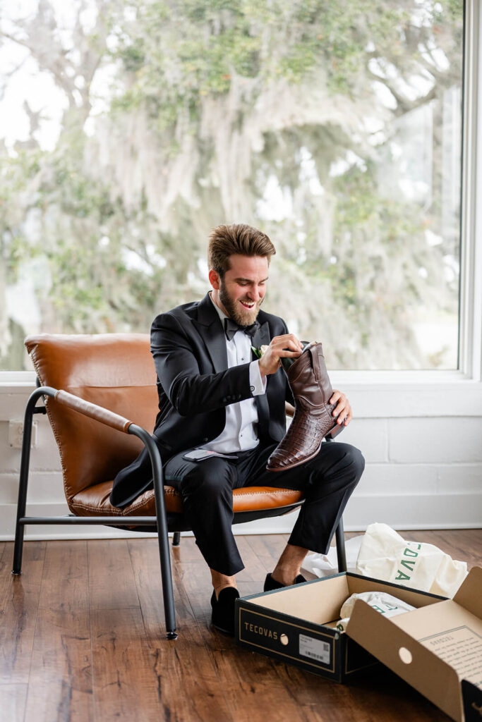 Groom opening a present from his bride: Tecovas