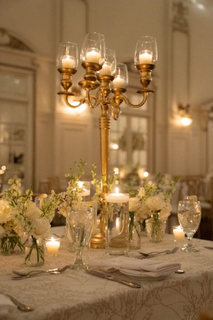 Wedding reception table with gold candelabras and romantic candlelight