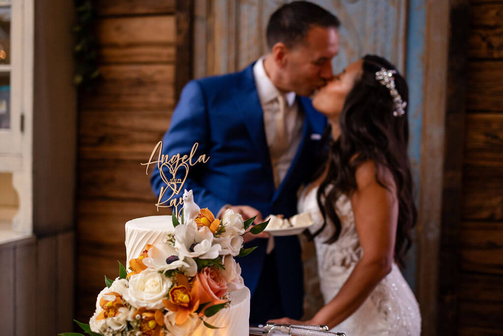 Bride and groom kissing after cutting their wedding cake