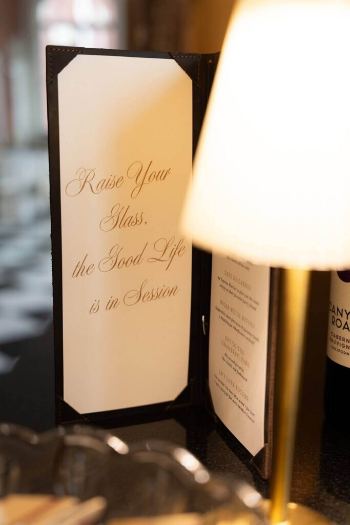 Wedding cocktail menu that reads "Raise Your Glass, the Good Life is in Session"