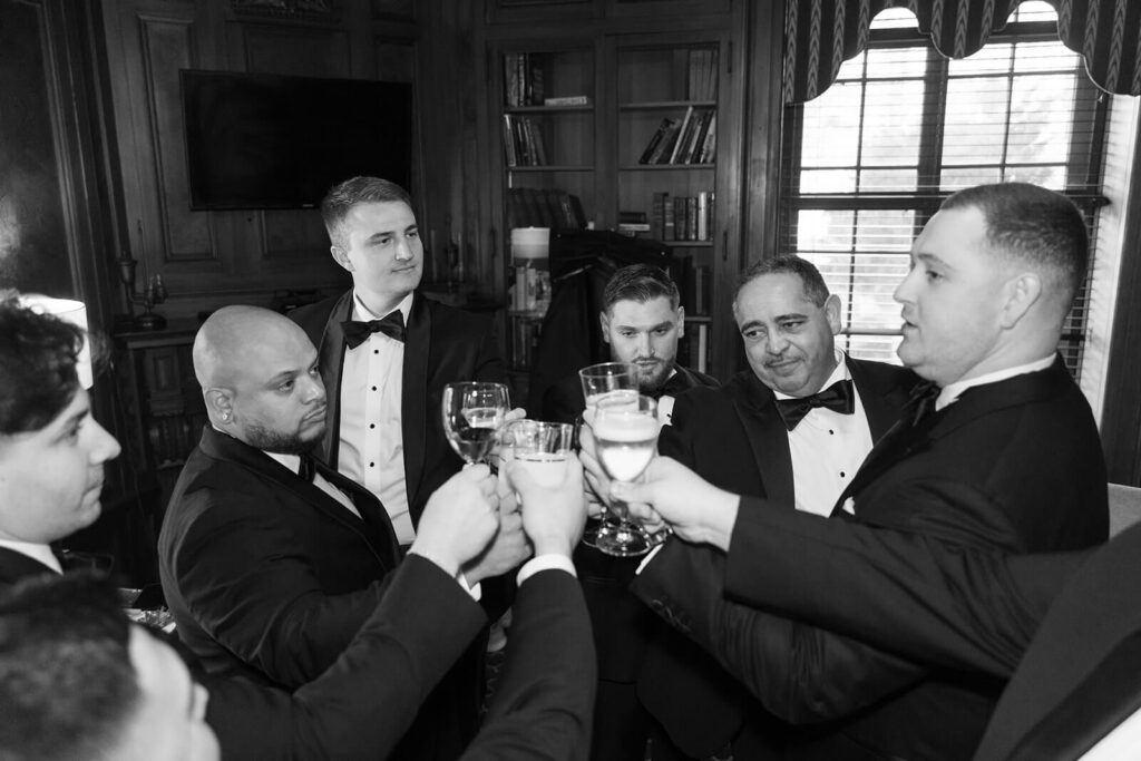 Groom and groomsmen toasting to the groom on his wedding day