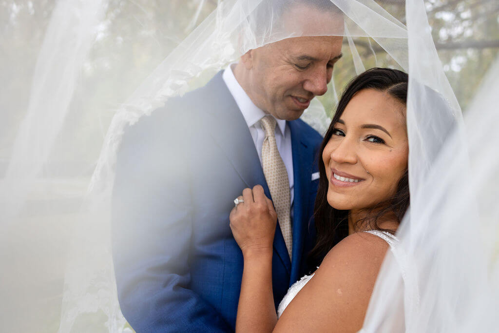 Bride and groom under a willow tree at their Cecil Creek Farm wedding