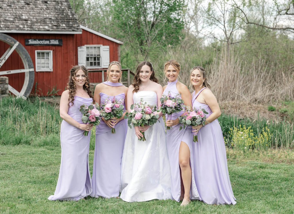 Bride with bridal party wearing long, formal lavender dresses