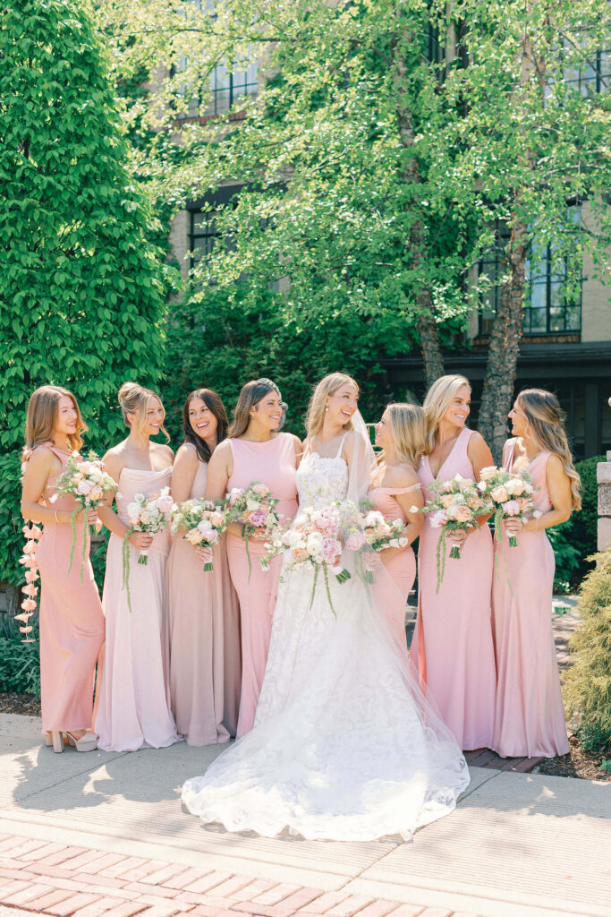 Bride with bridesmaids dressed in shades of light pink