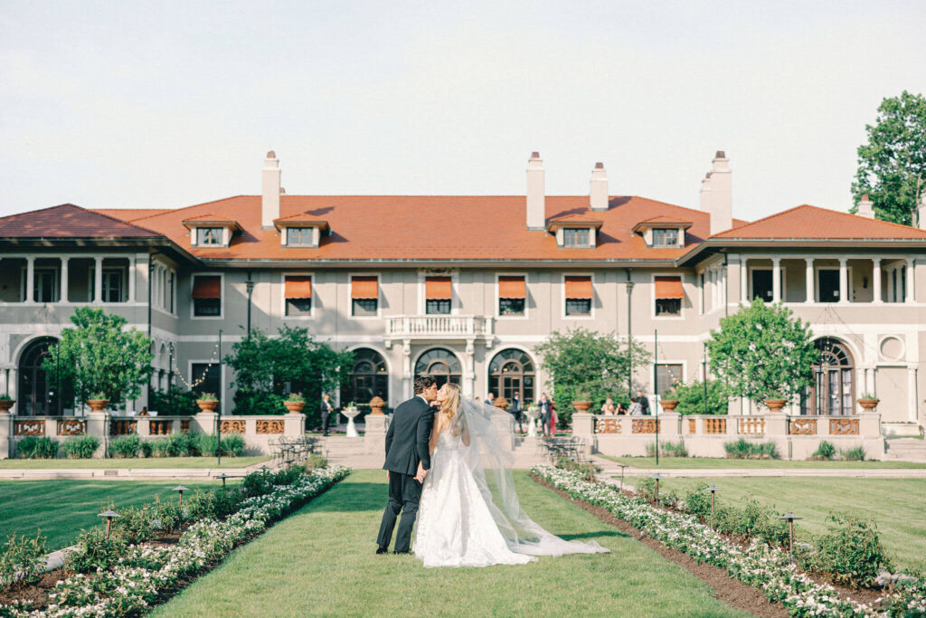 Bride and groom kiss in front of their wedding venue: The Armour House