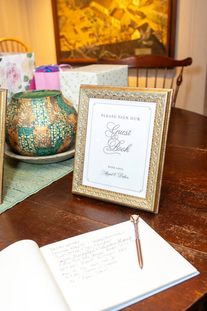 Traditional script guest book sign in a gold frame