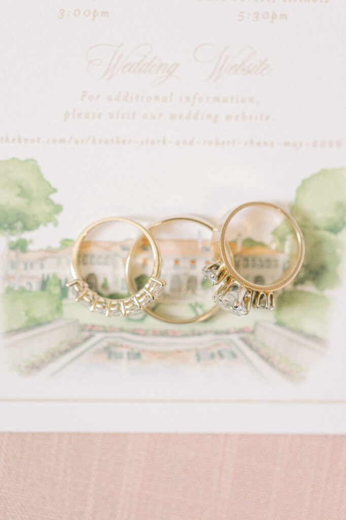 Rings sitting on top of a details card featuring a custom watercolor illustration of The Armour House