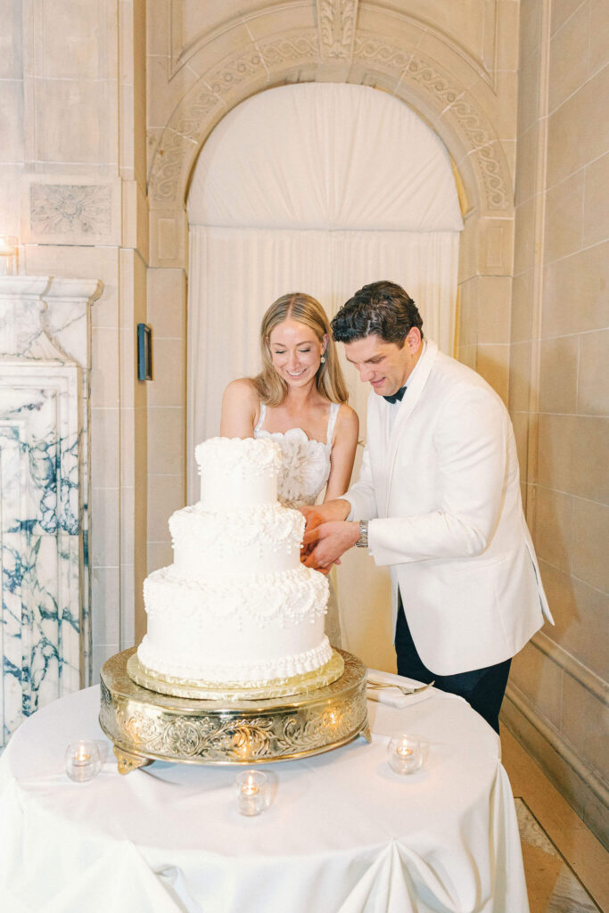 Bride and groom cutting a 3-tiered wedding cake