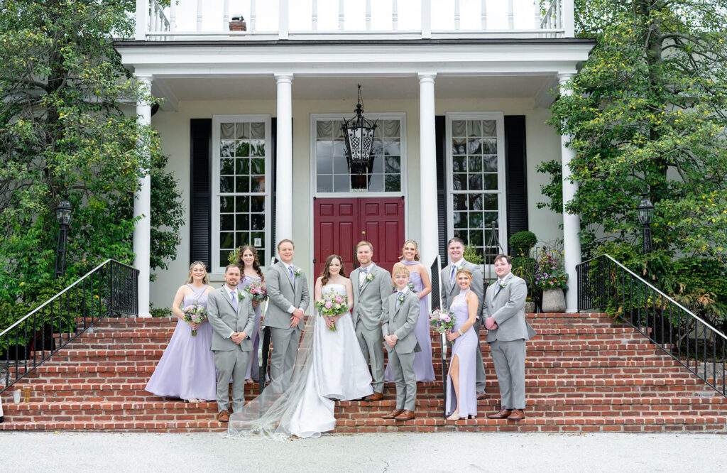 Bride and groom with wedding party on the steps of the Kimberton Inn