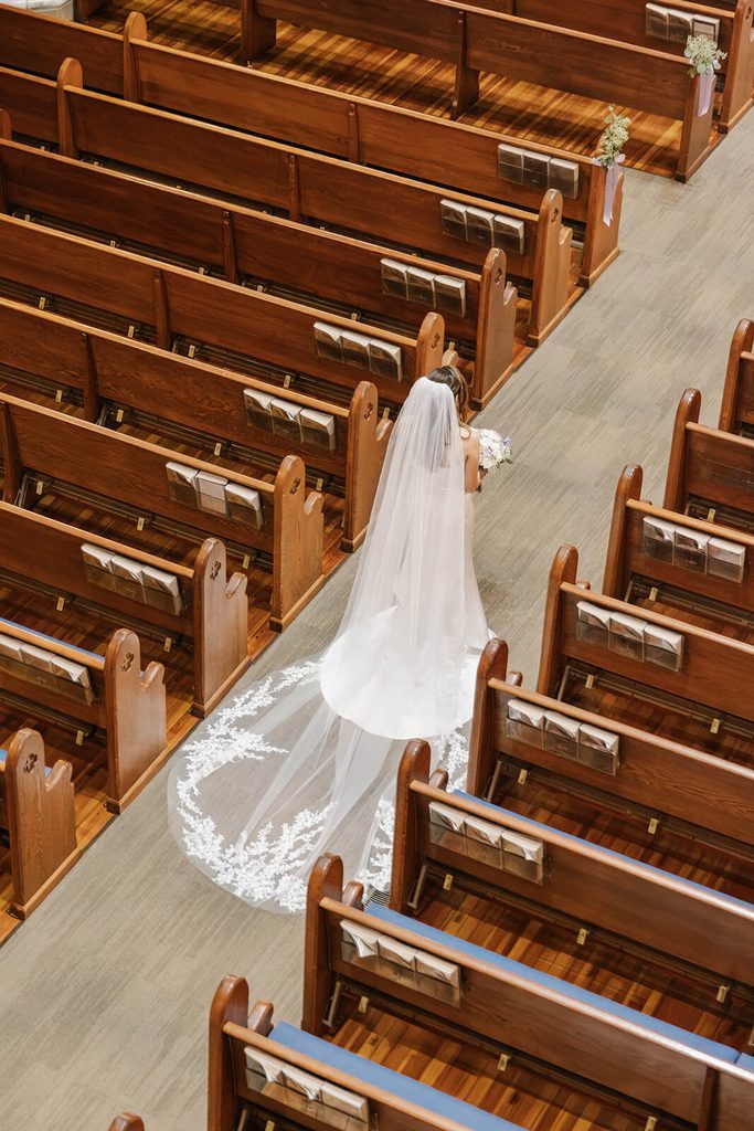 Bride walking down the aisle in a cathedral veil