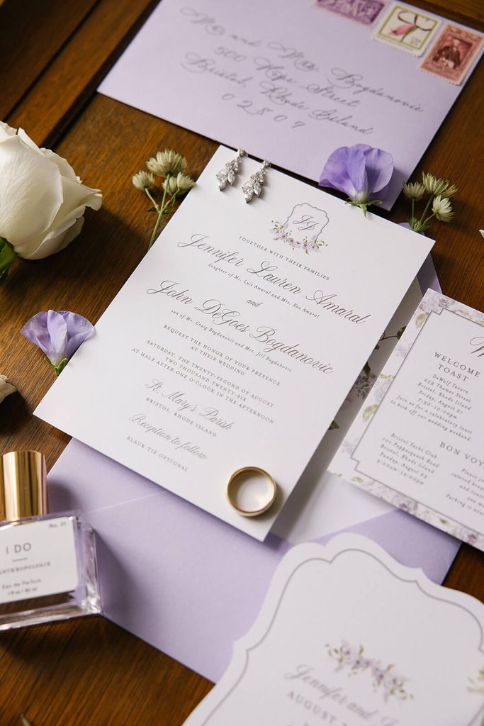 Elegant purple wedding invitations with a custom floral crest