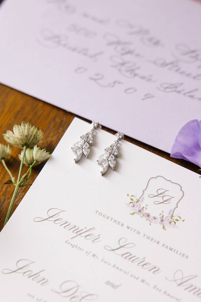 Elegant wedding invitations with a custom purple floral crest