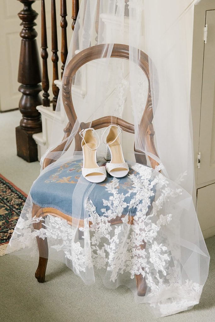 Bridal veil draped over an elegant chair with shoes on top